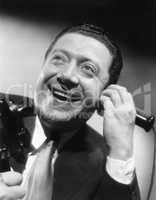 Portrait of a man on the telephone laughing and happy