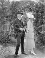 Husband stopping his wife to continue walking through the garden