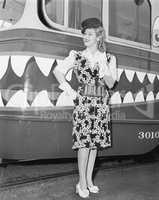 Female conductor standing in front of a tour trolley
