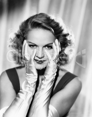 Woman framing her face with satin gloved hands