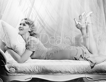 Woman lying on a chaise lounge with her legs up