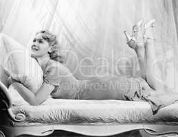 Woman lying on a chaise lounge with her legs up