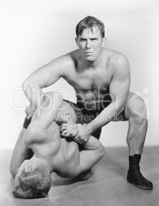 Two men wrestling with each other