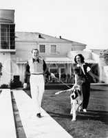 Couple walking their St. Bernard outside their home