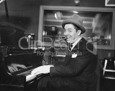 Man with a big smile and a cigar in his mouth playing the piano