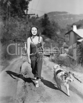 Woman walking her Collie on a country road