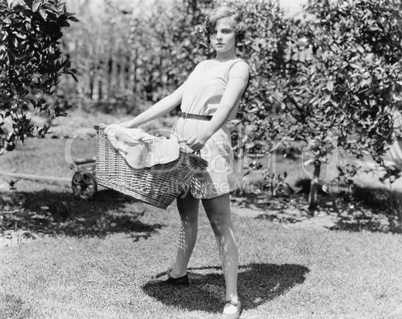 Young woman carrying a basket of laundry