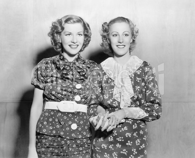 Two young women standing together and holding hands