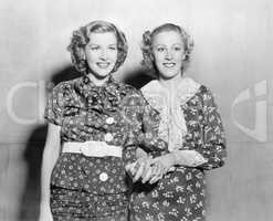 Two young women standing together and holding hands