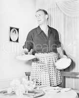 Man in an apron setting the table