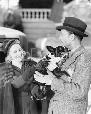 Man and woman holding a little dog