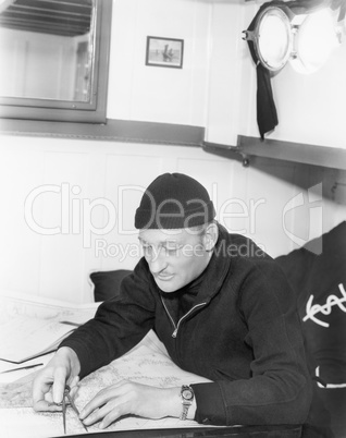Sailor looking over a map with a compass