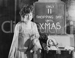 Woman with sign with number of shopping days until Christmas
