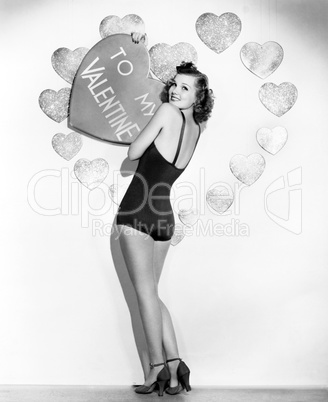 Portrait of woman holding large valentine