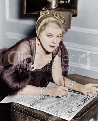 Woman doing puzzle in newspaper