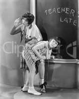Teacher spanking a girl in a classroom