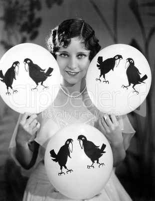 Portrait of a young woman balancing balloons on her hands and knees