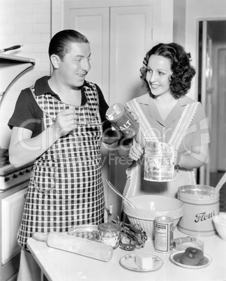 Couple together in the kitchen baking a cake