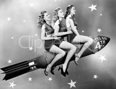 Three women sitting on a rocket