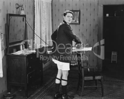 Man in sock garters ironing