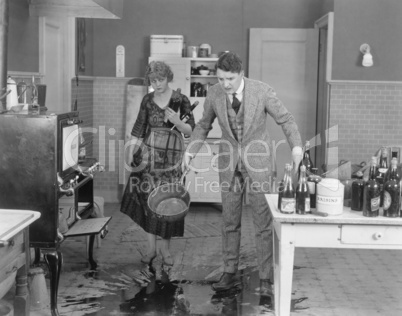 Man and woman looking at spilled liquid on kitchen floor