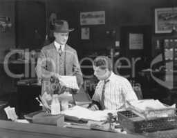 Man with attitude showing papers to office worker