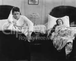 Young couple in separate beds after fight