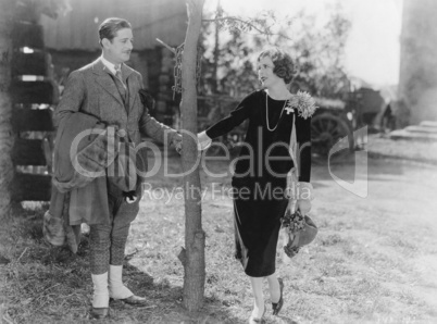 Couple holding hands by tree