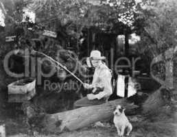 Young man fishing with his dog