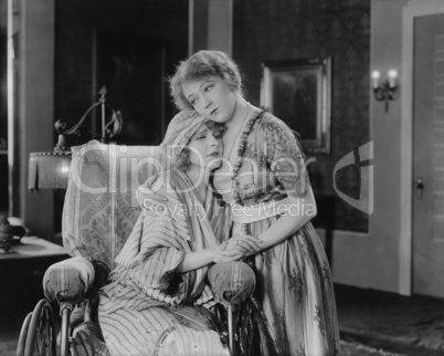 Young woman consoling her friend in wheelchair