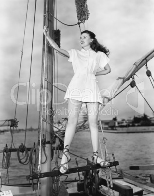 Smiling woman on boat holding mast