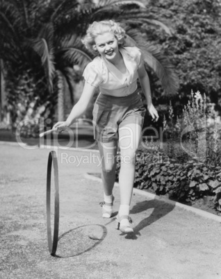 Young smiling woman playing with hoop