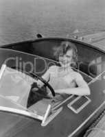 Woman behind steering wheel in motor boat