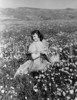 Woman collecting flowers in field