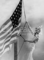 Smiling woman hoisting American flag
