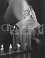 Nun lighting candles in church