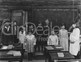 Group portrait of children standing in classroom