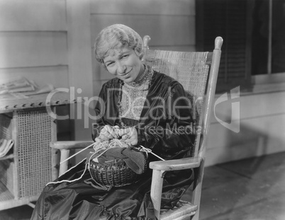 Smiling woman knitting in her rocking chair