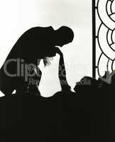 Silhouette of man kissing reclining woman's hand