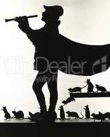 Silhouette of Pied Piper followed by rats