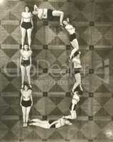 High angle view of women forming the letter "D"