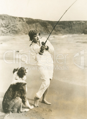 Fishing at the beach with her dog