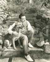 Young man sitting with dog on steps outdoors