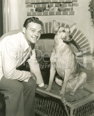 Young man sitting with dog at home