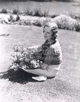 Woman sitting with basket of flowers