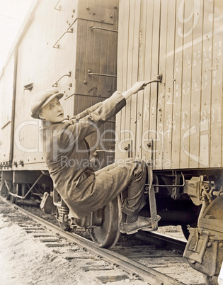 Female hobo climbing freight train