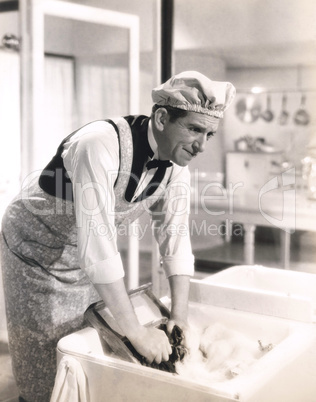 Man washing clothes in the kitchen sink