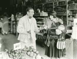 Vendor bargaining with woman at market