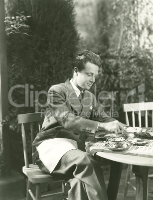 Young man having breakfast at outdoor table