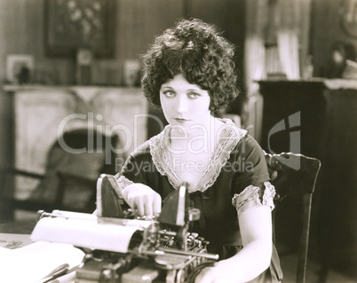 Thoughtful businesswoman with typewriter at desk in office